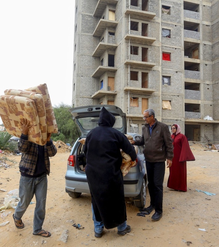 A displaced Libyan woman cleans up their room in an unfinished building in the Libyan capital Tripoli on December 18, 2019. -AFP