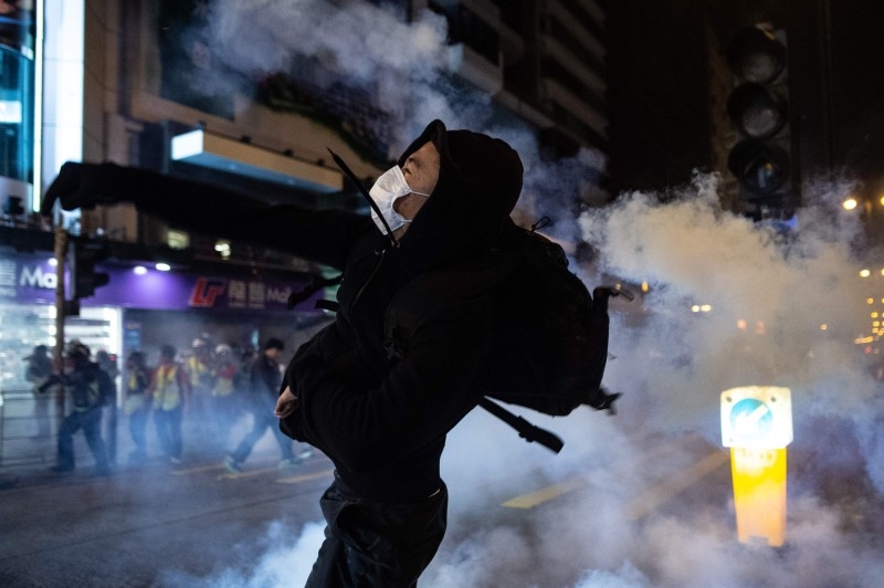 A protester reacts after police fire tear gas to disperse bystanders in a protest in Jordan district in Hong Kong on Wednesday. — AFP