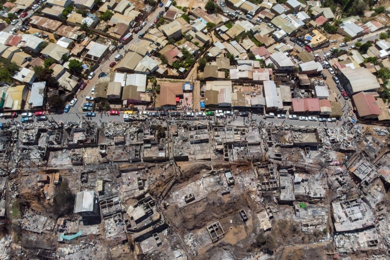 Locals search for personal belongings after a forest fire at the Rocuant hill in Valparaiso, Chile, on Wednesday. — AFP