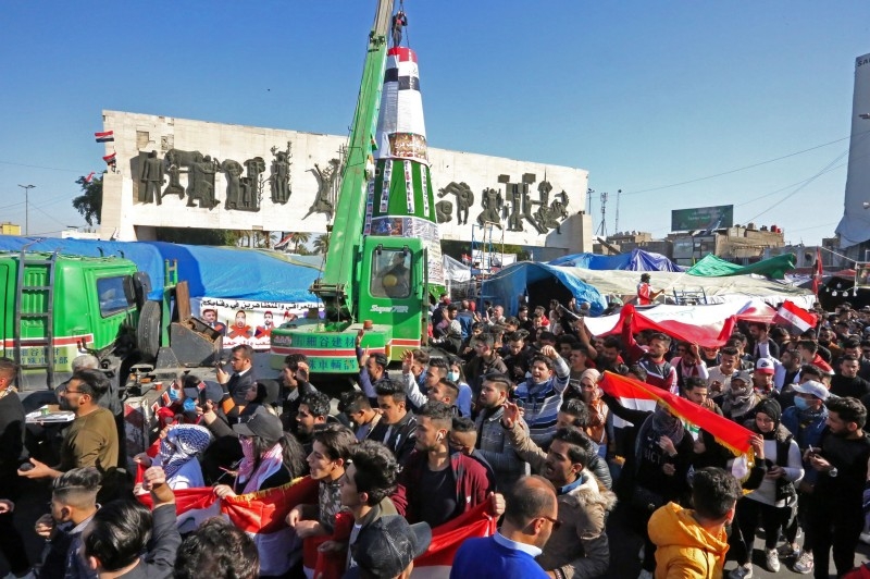 Iraqi anti-government protesters erect a Christmas tree in the capital Baghdad's central Tahrir Square on on Tuesday. — AFP