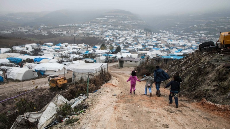 Hussein Berro, a 51-year-old displaced Syrian, sits with his children inside their tent at a camp in Khirbet Al-Joz in the west of the northwestern Idlib province near the border with Turkey, in this Dec. 12, 2019 file photo. — AFP