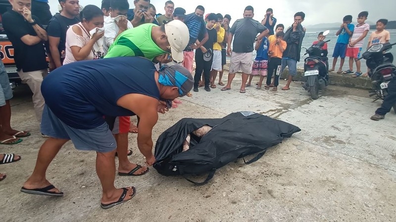 Residents attempt to identify a body, believed to be one of several fishermen who went missing at the height of Typhoon Phanfone that pummeled the central Philippines on Christmas Day, in Borongan, Eastern Samar province, on Friday. — AFP
