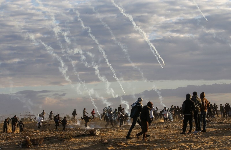 A Palestinian protester uses a sling to hurl stones at Israeli troops at the Israel-Gaza border fence, east of Rafah in the southern Gaza Strip, on Friday. — AFP