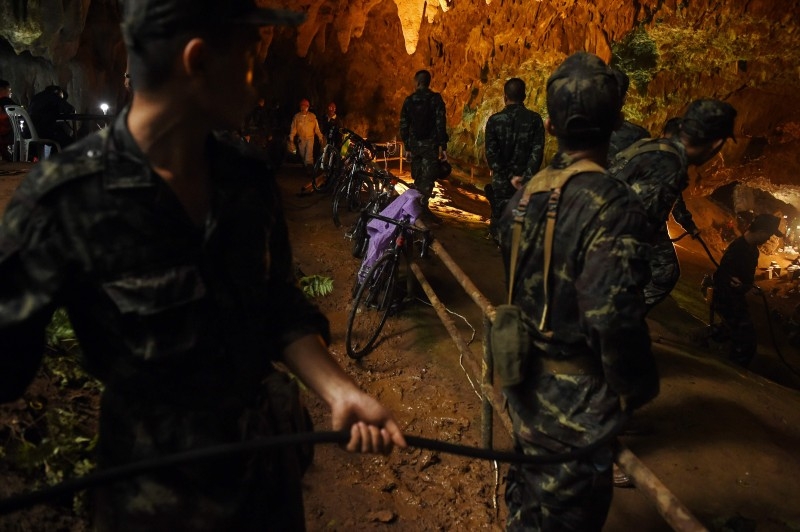  In this file photo taken on June 26, 2018, Thai soldiers relay electric cable deep into the Tham Luang cave at the Khun Nam Nang Non Forest Park in Chiang Rai, during a rescue operation for a missing children's football team and their coach. -AFP