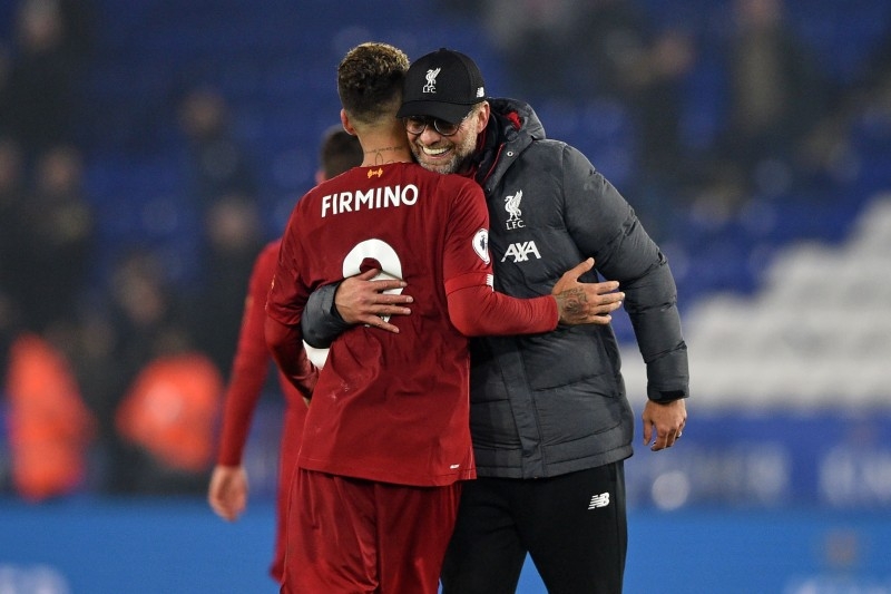 Liverpool's German manager Jurgen Klopp (R) embraces Liverpool's Brazilian midfielder Roberto Firmino (L) as they celebrate on the pitch after the English Premier League football match against Leicester City at King Power Stadium in Leicester, central England on Dec. 26, 2019. — AFP