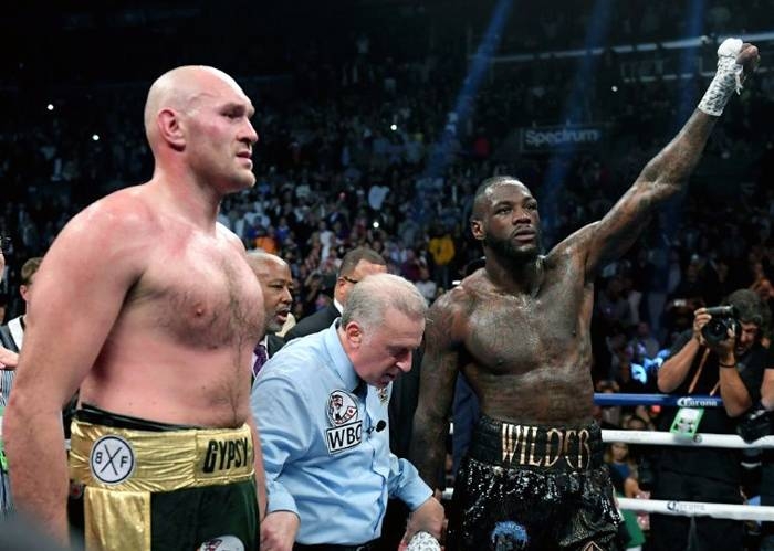 Tyson Fury and Deontay Wilder wait for a decision with referee Jack Reiss before a draw is announced in their WBC heavyweight world title fight in Los Angeles on Dec. 1, 2018. — AFP