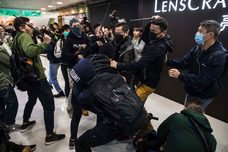 A plainclothes police officer (L) clashes with a pro-democracy protester during a rally inside a shopping mall in Sheung Shui in Hong Kong on Saturday. -AFP