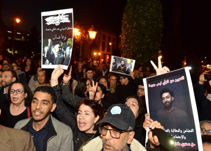 Demonstrators shoot slogans and hold a banner showing a portrait of Omar Radi, a Moroccan journalist detained over tweet criticizing judge, during a demonstration in the city of Rabat on Saturday. -AFP