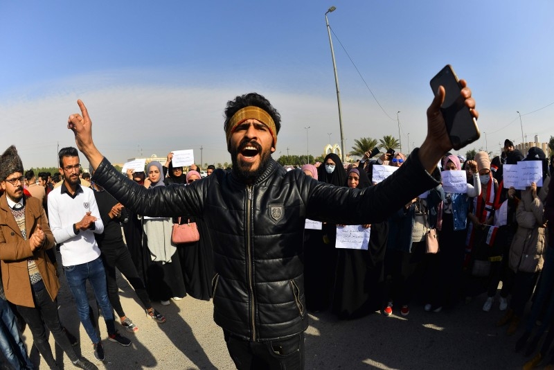 Iraqi university students take part in an anti-government demonstration in Najaf on Sunday. -AFP