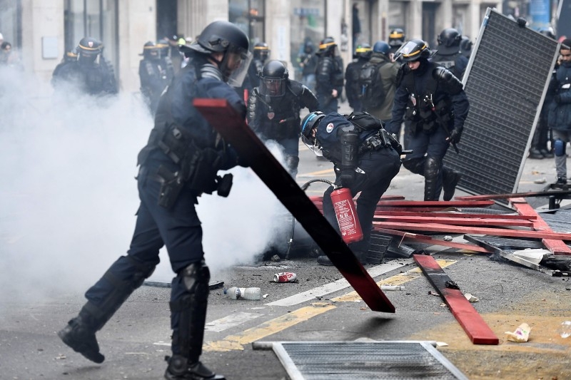 Protesters demonstrate as part of a nationwide multi-sector strike against French government's pensions overhaul near the city hall in Paris on Saturday. -AFP