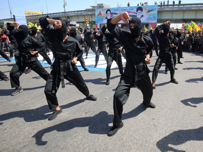 In this file photo taken on May 31, 2019 Iraqi Shiite fighters from the Iran-backed armed group, Hezbollah brigades, march during a military parade marking Al-Quds (Jerusalem) International Day in Baghdad. The US bombed the headquarters of the group in Iraq and Syria, the Pentagon said Sunday, after a series of attacks in Iraq against American interests. -AFP