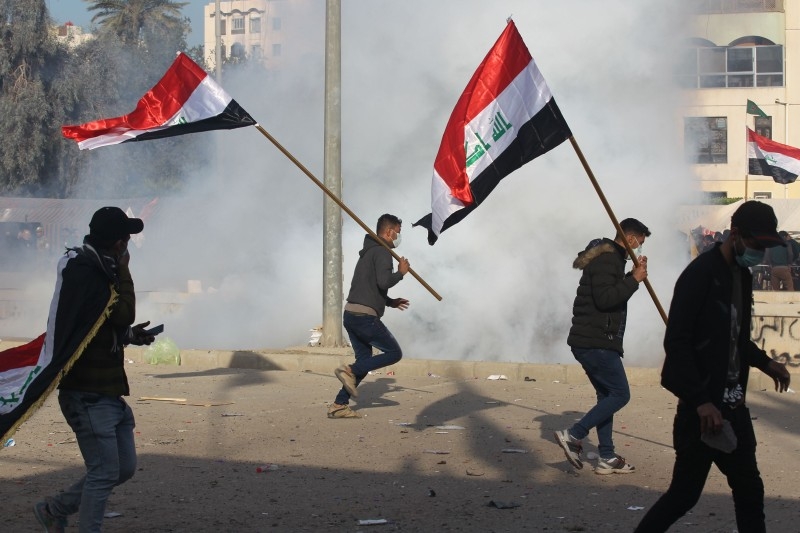 US forces, unseen, fire teargas canisters at supporters and members of the Hashed Al-Shaabi paramilitary force during a demonstration outside the US embassy in the Iraqi capital Baghdad on Wednesday. — AFP