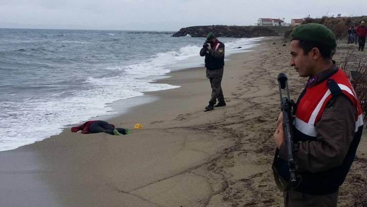 Turkish soldiers take photos of the body of a migrant washed up ashore in Izmir's Dikili district in this Jan. 5, 2016 file photo. — AFP