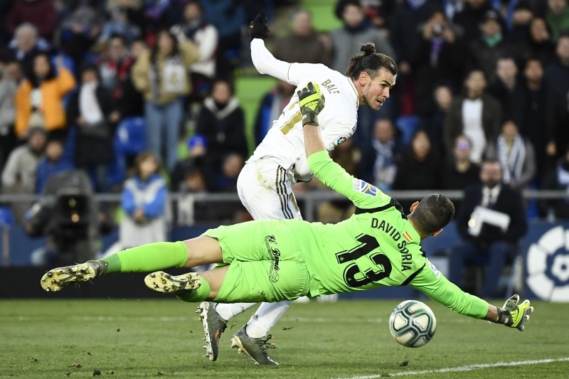 Real Madrid's Welsh forward Gareth Bale (Top) vies with Getafe's Spanish goalkeeper David Soria during the Spanish league football match between Getafe CF and Real Madrid CF at the Col. Alfonso Perez stadium in Getafe on Saturday. — AFP 