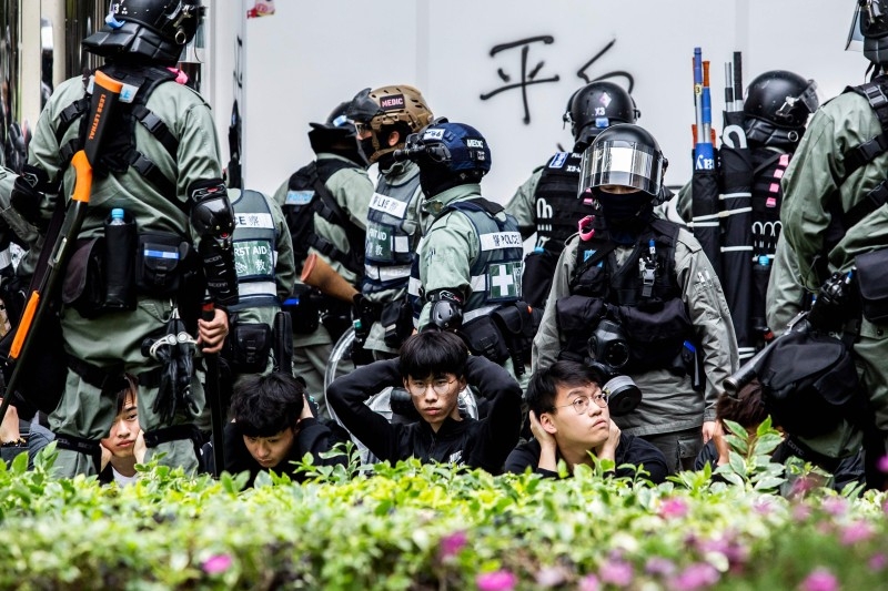 People are detained by police during a clearance operation after a demonstration against parallel trading in Sheung Shui in Hong Kong on Sunday. -AFP