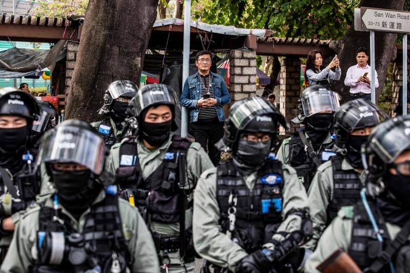 People are detained by police during a clearance operation after a demonstration against parallel trading in Sheung Shui in Hong Kong on Sunday. -AFP