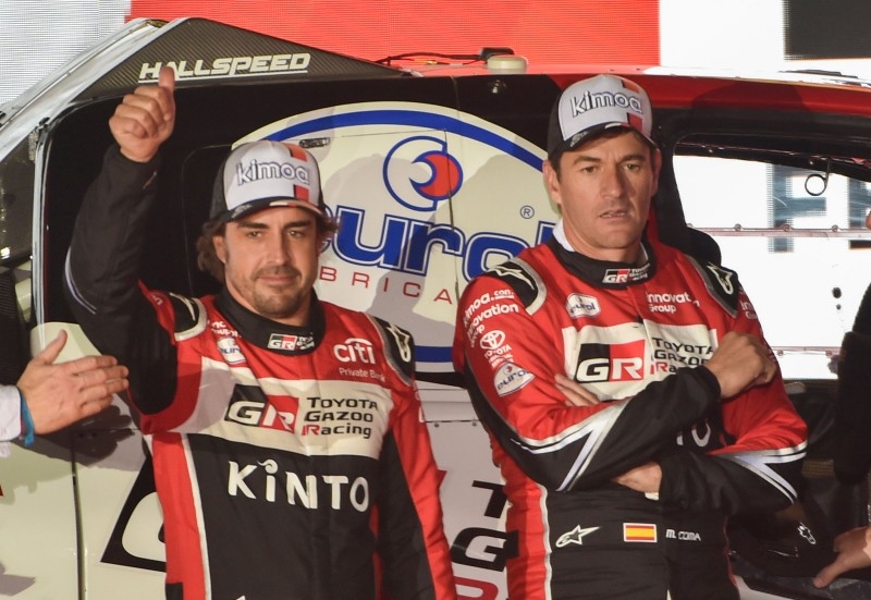 Toyota Gazoo Racing's Spanish driver Fernando Alonso (L) gives the thumbs-up as his Spanish co-driver Marc Coma looks on during the podium ceremony in Jeddah, on Saturday, ahead of the 2020 Dakar Rally, which began on Sunday. — AFP