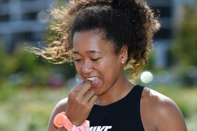 Tennis player Naomi Osaka of Japan tries a lamington cake after taking a sightseeing ride in a helicopter at the Queensland Tennis Centre in Brisbane on Jan. 2, 2020, ahead of the Brisbane International tennis tournament starting on Monday. — AFP