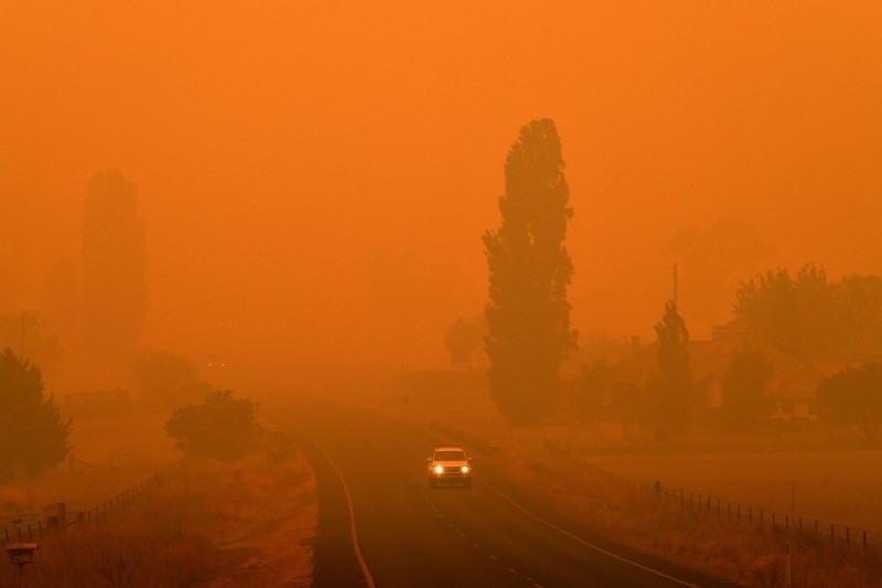 Residents commute on a road through thick smoke from bushfires in Bemboka, in Australia's New South Wales state on Sunday. Australians counted the cost from a day of catastrophic bushfires that caused 