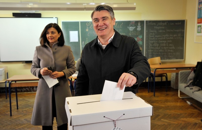 Former Croatian Prime Minister Zoran Milanovic (R) accompanied by his wife Sanja Music Milanovic casts his ballot at a polling station during the presidential elections on Sunday in Zagreb, Croatia. — AFP