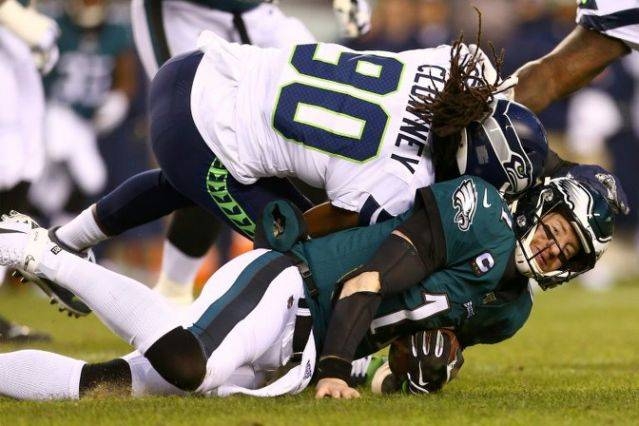 Philadelphia Eagles quarterback Carson Wentz, bottom, is hit by Seattle's Jadeveon Clowney and sent off for the rest of Sunday's NFL playoff game. — AFP