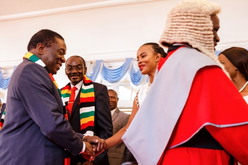 Zimbabwe's President Emmerson Mnangagwa, left, shakes hands with Mary Chiwenga, wife of newly appointed Vice President Constantino Chiwenga, as also newly appointed Vice-President Kembo Mohadi looks on after a swearing-in ceremony for Zimbabwe's new vice presidents by the country's Chief Justice at the State House in Harare in this Aug. 30, 2018 file photo. — AFP 