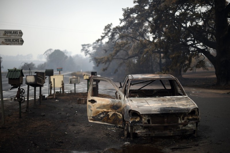 A burnt vehicle is seen on Quinlans street after an overnight bushfire in Quaama in Australia's New South Wales state on Monday. Reserve troops were deployed to fire-ravaged regions across three Australian states after a torrid weekend that turned swathes of land into smoldering, blackened hellscapes. — AFP