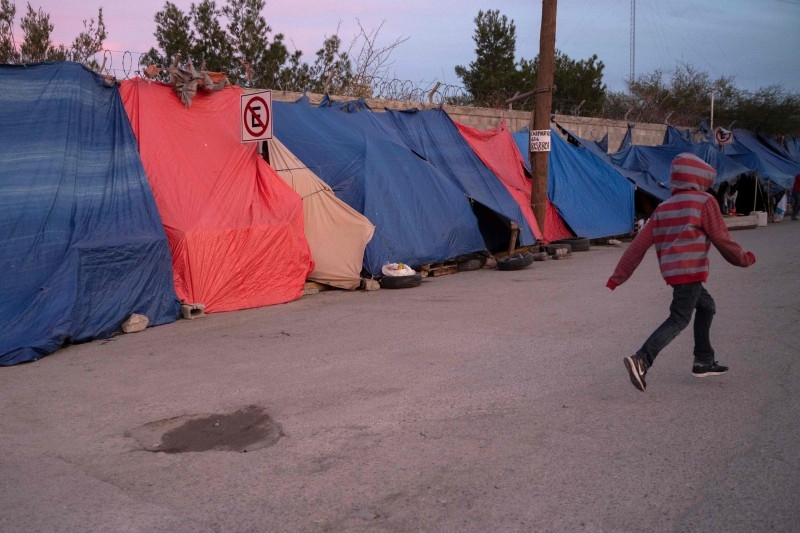  In this file photo taken on December 11, 2019 a boy runs past tents at an asylum seekers camp near the Zaragoza bridge in Ciudad Juarez, Mexico. -AFP