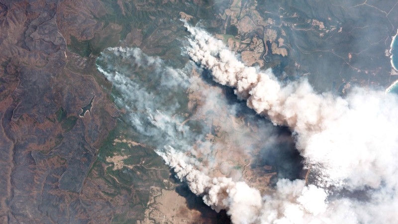This handout satellite image taken on December 31, 2019 and received from Planet Labs, Inc. on January 7, 2020 shows smoking rising into the air from bushfires near Lake Conjolia in the Australian state of New South Wales. -AFP