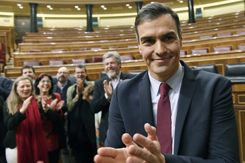 Spanish caretaker prime minister, socialist Pedro Sanchez, applauds after winning a parliamentary vote to elect a premier at the Spanish Congress (Las Cortes) in Madrid on Tuesday. Spain's parliament today confirmed Socialist leader Pedro Sanchez by a razor-thin margin as prime minister for another term at the helm of the country's first-ever coalition government since its return to democracy in the 1970s. — AFP
