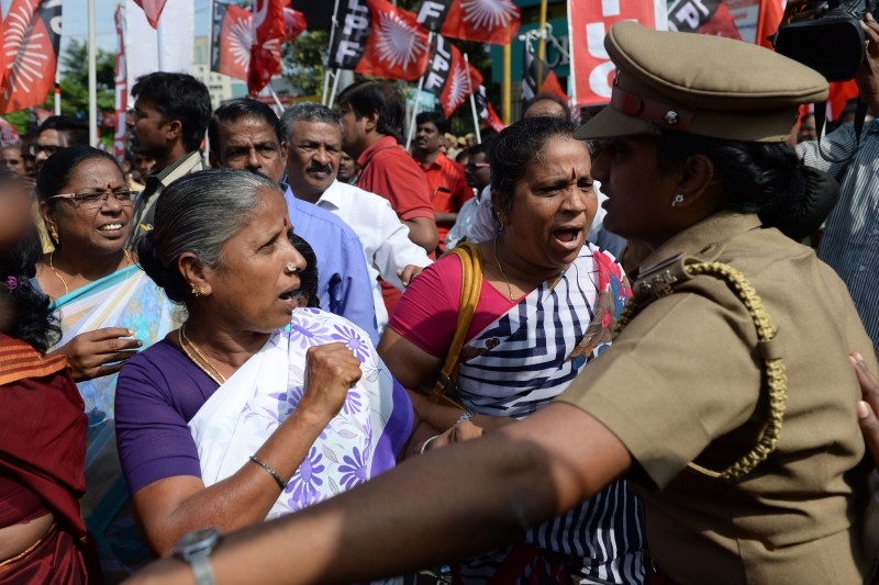 Police stand beside a poster board announcing a strike, outside the Reserve Bank of India (RBI), during a nationwide general strike called by trade unions aligned with opposition parties to protest the Indian government's economic policies in Hyderabad on Wednesday. -AFP