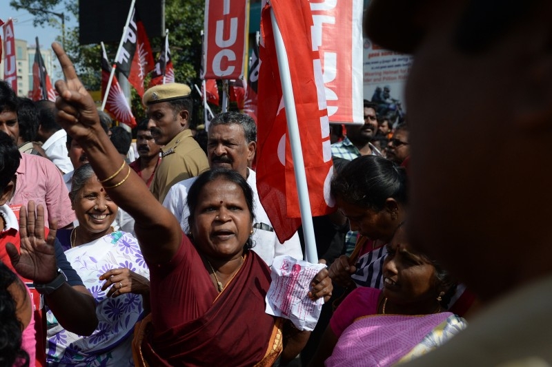Police stand beside a poster board announcing a strike, outside the Reserve Bank of India (RBI), during a nationwide general strike called by trade unions aligned with opposition parties to protest the Indian government's economic policies in Hyderabad on Wednesday. -AFP