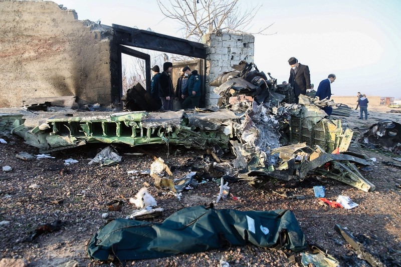 People stand near the wreckage after a Ukrainian plane carrying 176 passengers crashed near Imam Khomeini airport in Tehran on Wednesday. -AFP