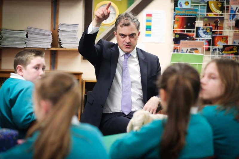 Britain's Northern Ireland Secretary Julian Smith talks with school children during his visit to Maghaberry Primary School in Moira, near Belfast, Northern Ireland, on Friday. A draft deal to revive Northern Ireland's defunct government was published on Thursday, three years to the day since the province's executive collapsed in acrimony. — AFP
