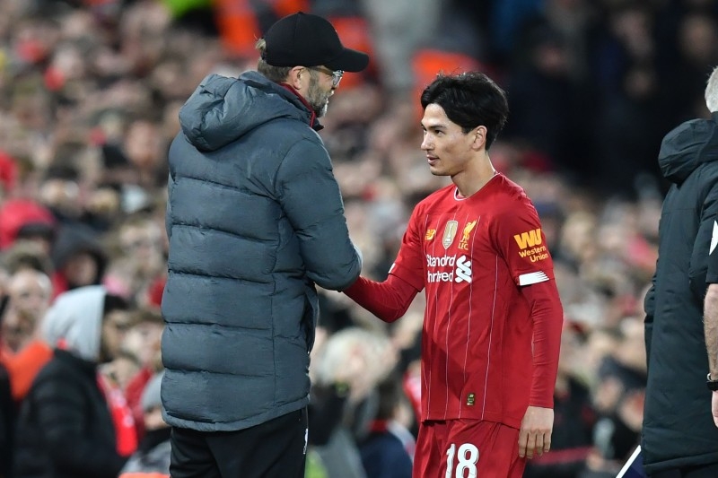 Liverpool's German manager Jurgen Klopp (L) speaks with Liverpool's Japanese midfielder Takumi Minamino (R) as he's substituted during the English FA Cup third round football match between Liverpool and Everton at Anfield in Liverpool, north west England on Jan. 5, 2020.  — AFP