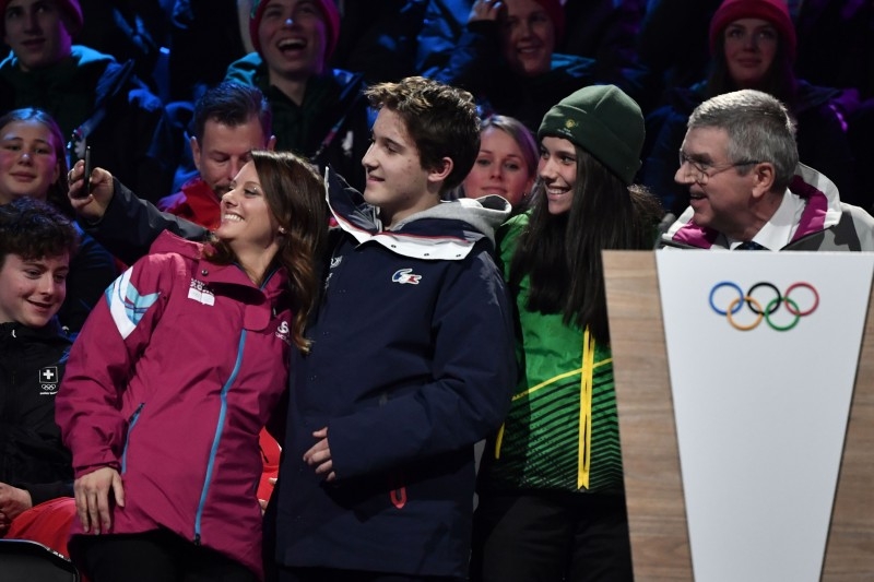 International Olympic Committee (IOC) president Thomas Bach (R) and 2020 Winter Youth Olympics president Virginie Faivre (L) pose for a selfie with young athletes during the opening ceremony of the Lausanne 2020 Winter Youth Olympic Games in Lausanne on Thursday. — AFP