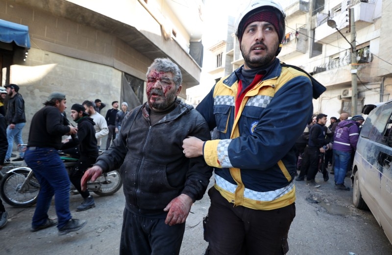 An injured man is helped to an ambulance following an air strike by pro-regime forces in the northwestern city of Idlib on Saturday. — AFP