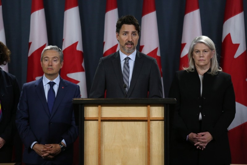 Canadian Minister of Foreign Affairs François-Philippe Champagne (L) and Deputy Minister of Defense Jody Thomas (R) listens as Prime Minister Justin Trudeau C) speaks during a news conference January 11, 2020 in Ottawa, Canada. -AFP