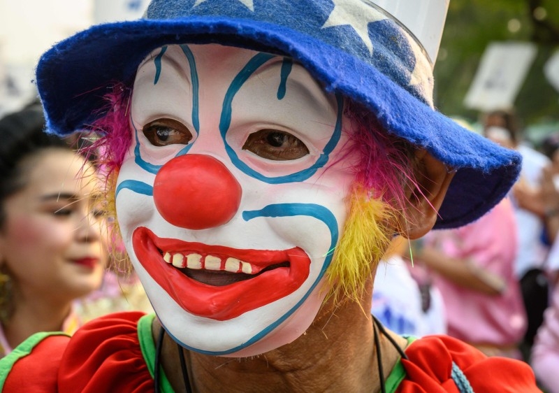 A man dressed as a clown takes part in a 