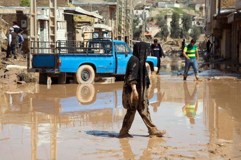 An Iranian woman walks through a flooded street in the city of Poldokhtar in this April 2, 2019 file photo. — AFP