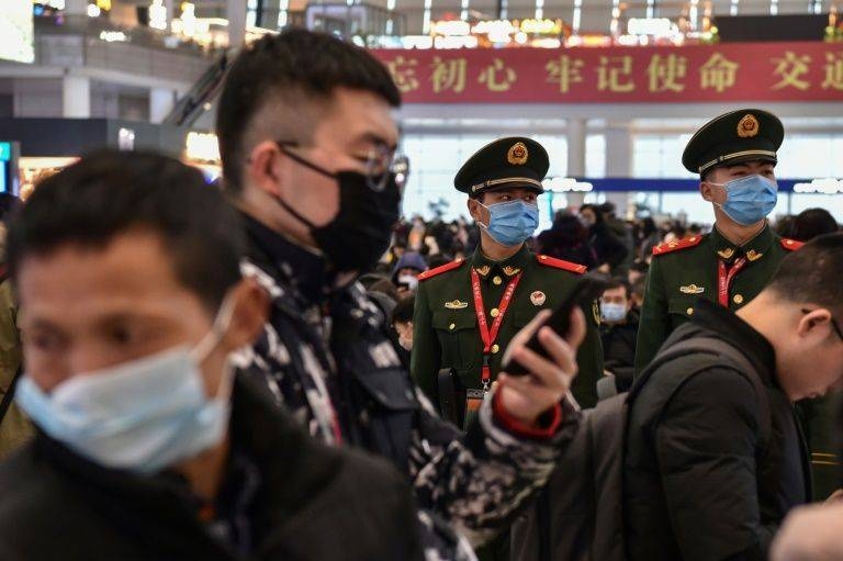 Chinese paramilitary police wearing masks stand guard at a Shanghai train station as the country faces a virus crisis at the start of the Lunar New Year holiday. — AFP