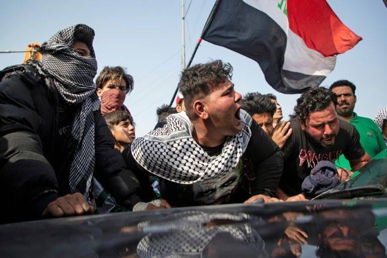 Angry Iraqi demonstrators mourn the killing of female activist and paramedic Janat Madhi, in Basra on Tuesday night, part of an upsurge of violence against the three-month-old protest movement. — AFP