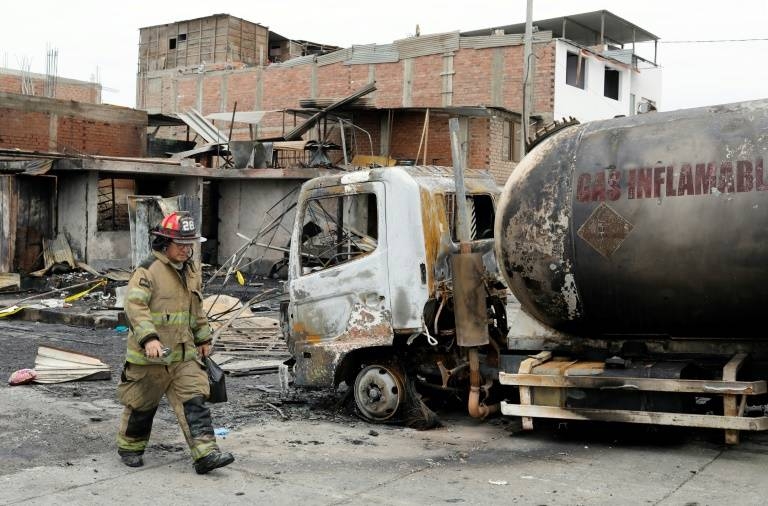 A fireman walks past the tanker truck that exploded in a Lima neighborhood, killing several people and igniting houses and cars in this on Jan. 23, 2020 file photo. — AFP