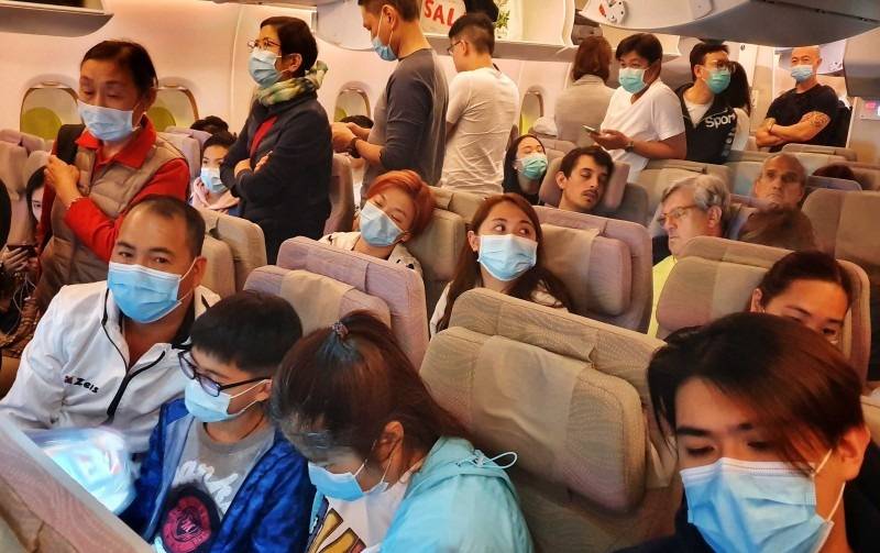 Passengers wear masks prepare to disembark from a flight from Hong Kong on arrival at Bangkok's airport ahead of the Chinese New Year in Bangkok in this Jan. 23, 2020 file photo. — AFP