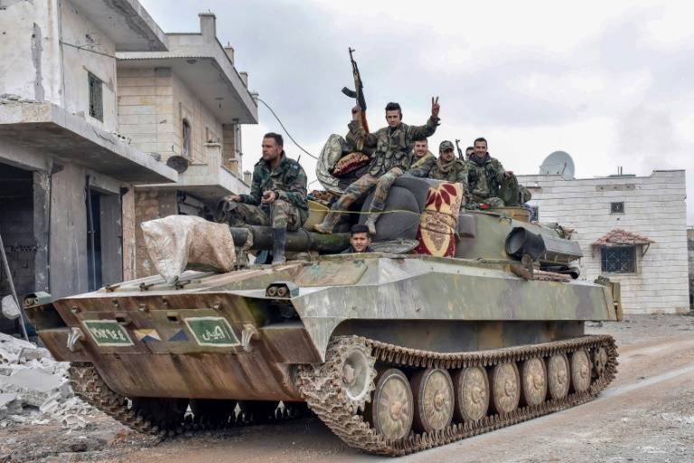 Syrian troops pass through a recaptured village in their final push on the strategic highway town of Maaret Al-Numan, held by the rebels for seven years. — Courtesy photo 