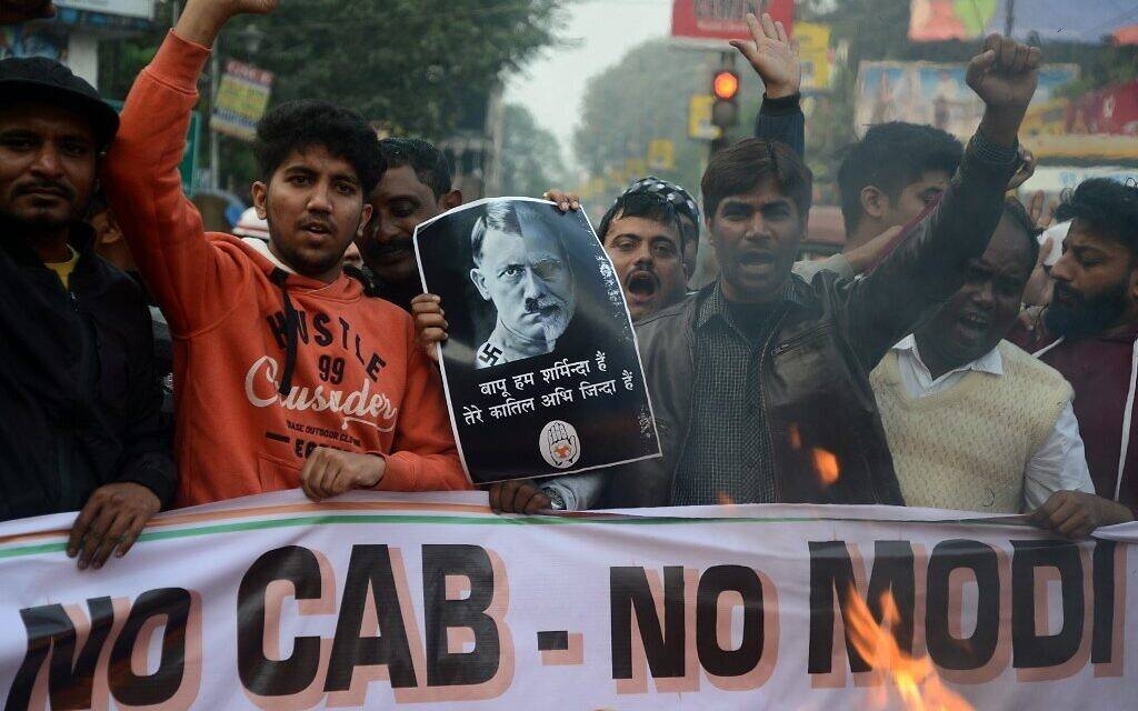 Protesters hold a poster comparing Indian Prime Minister Narendra Modi to German chancellor and Nazi Party leader Adolf Hitler at a demonstration against India's new citizenship law in Siliguri in this Dec. 18, 2019 file photo. — AFP
