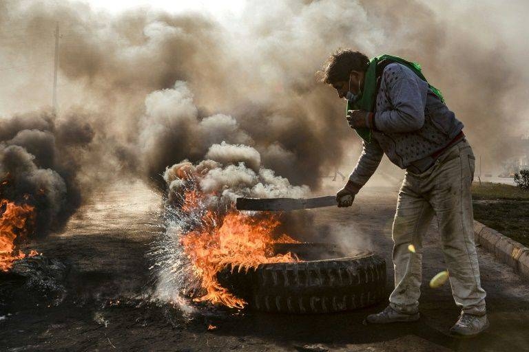 Anti-government protesters cut off a road with flaming tires during a demonstration against Iraq's prime minister-designate in the shrine city of Najaf, south of the capital. — AFP