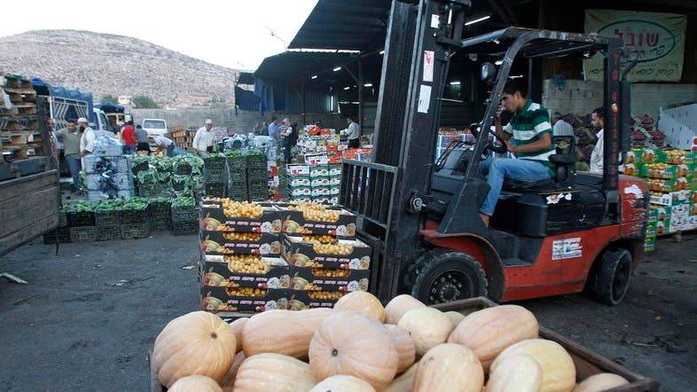 A worker operates a forklift at a wholesale vegetable and fruit market in the West Bank village of Beita, near Nablus. — Archives