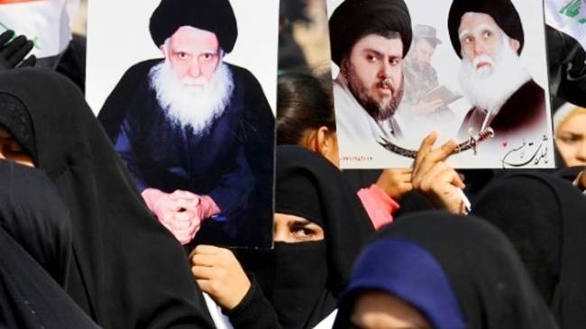 Women in Iraq's central city of Kufa hold up posters showing Moqtada Sadr (center) and his father Ayatollah Mohammed Sadeq Al-Sadr, killed under Saddam Hussein's regime in 1999. — AFP