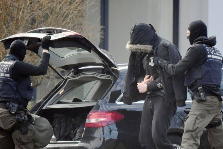 Police officers bringing a man believed to be one of the twelve men arrested in a nationwide probe against far-right activists, at the Federal Supreme Court in Karlsruhe, southern Germany, in this Feb 15, 2020 file photo. — AFP